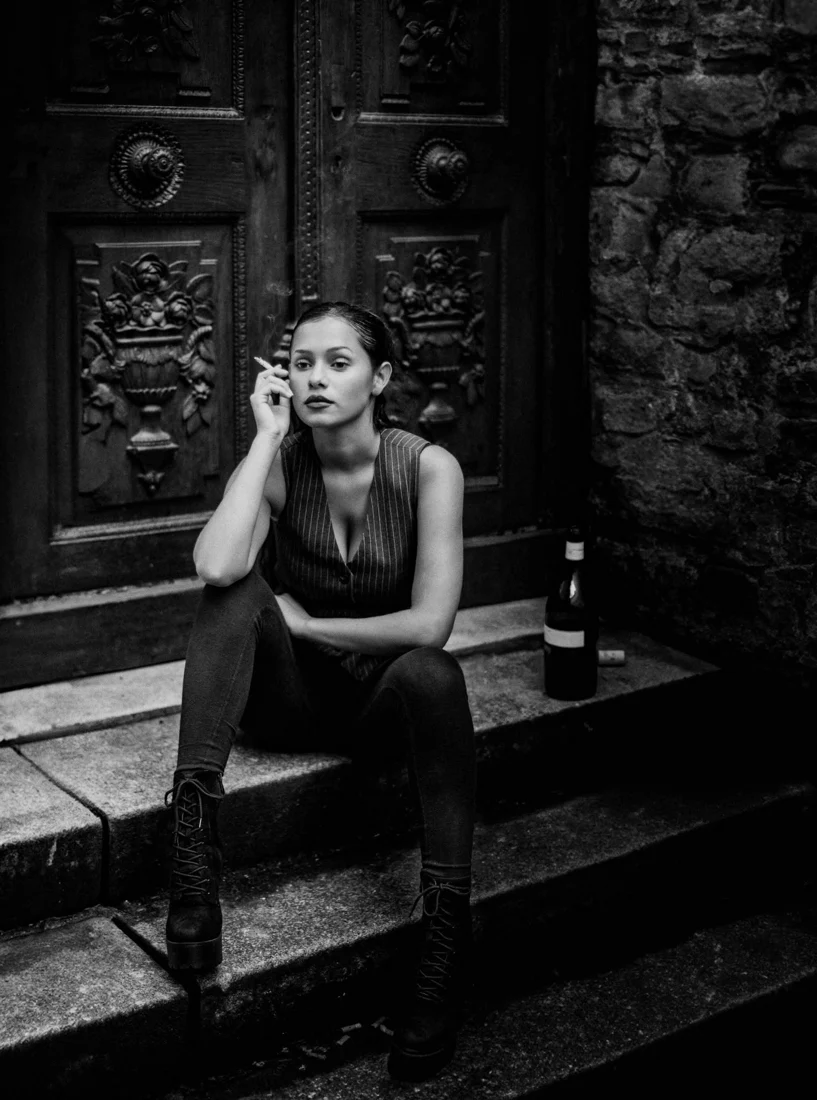 Woman sitting by ornate doors