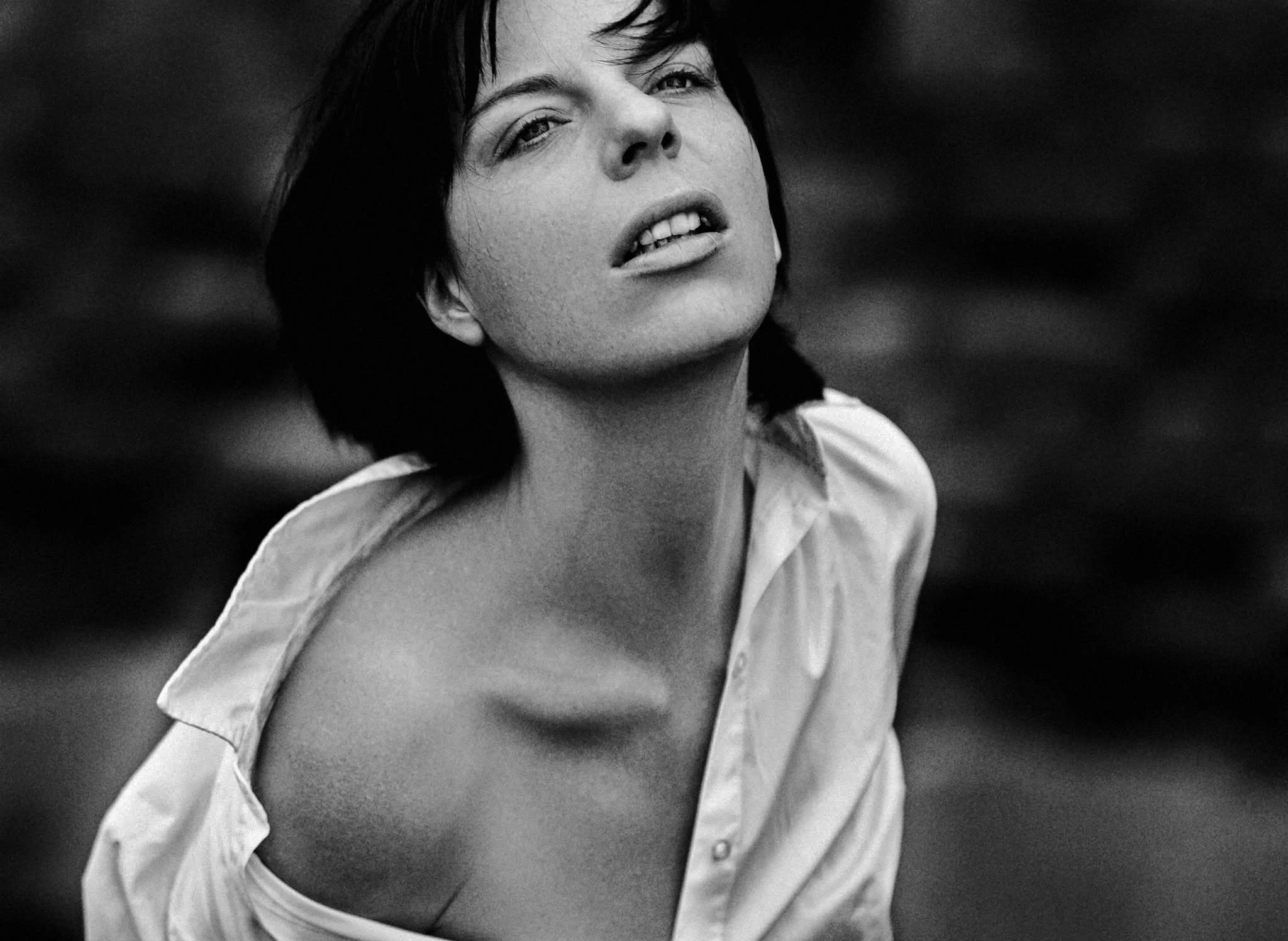 Black and white portrait of a woman in a loose white shirt