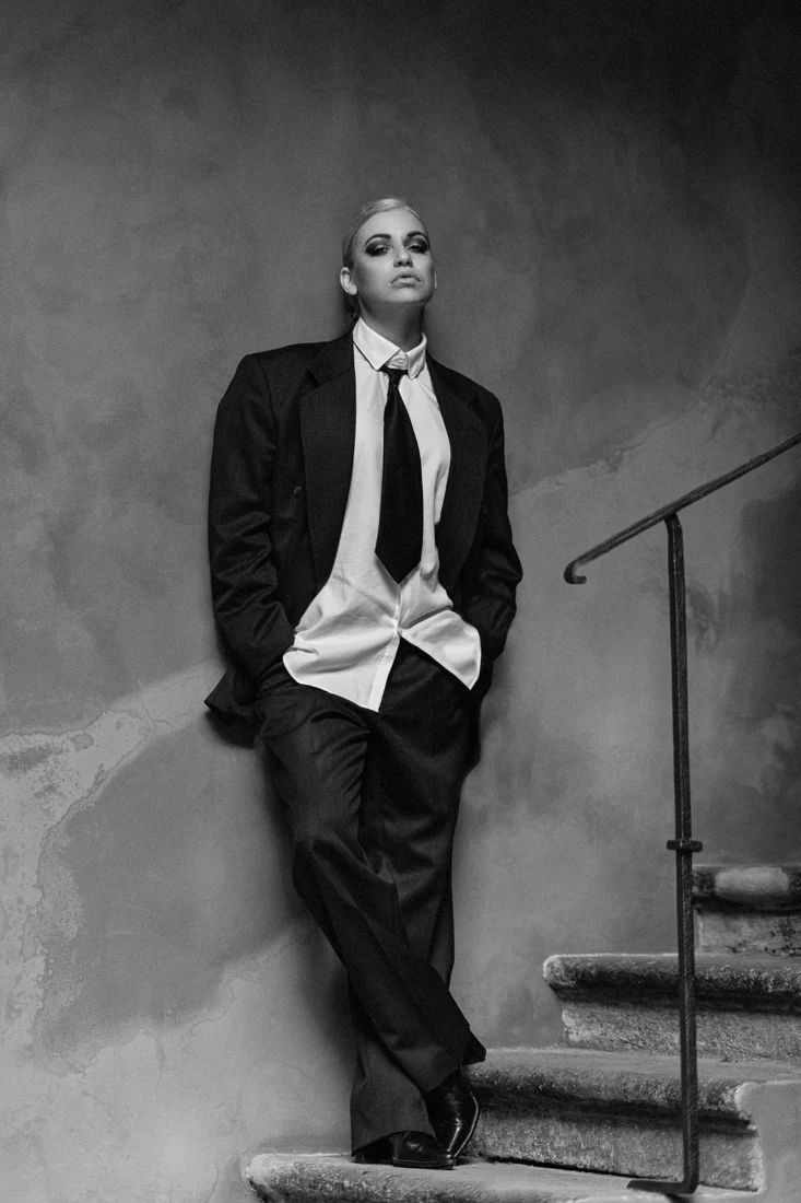 Full-length portrait of a woman in a suit by stairs
