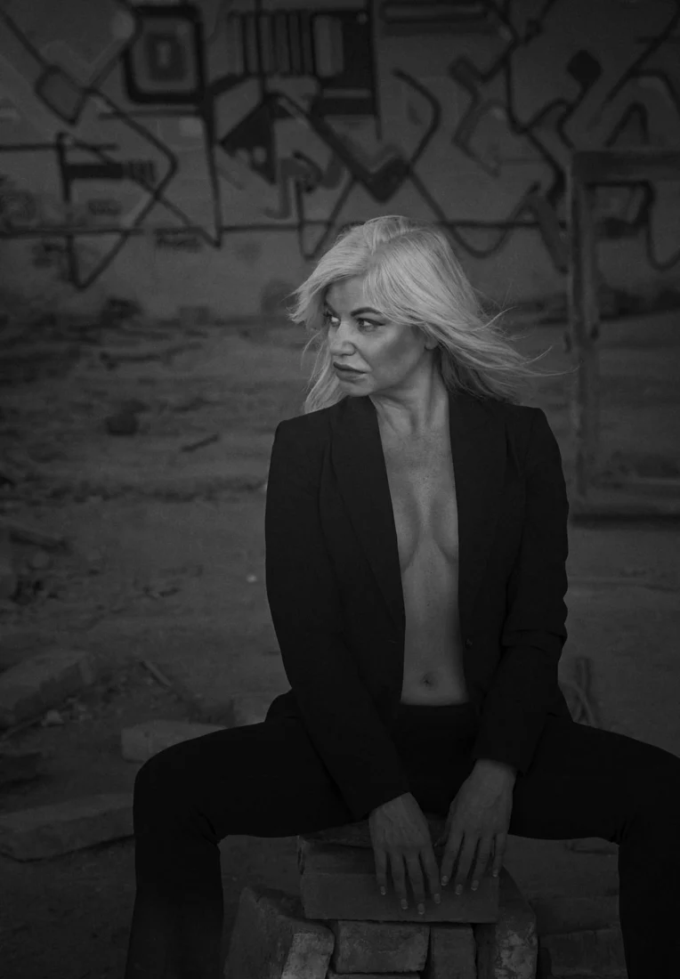 Woman in a jacket by a graffiti wall